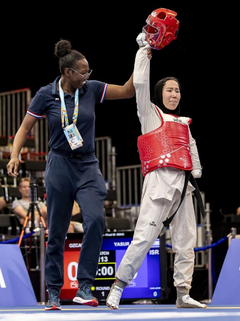 A female coach celebrates with a female Para taekwondo athlete