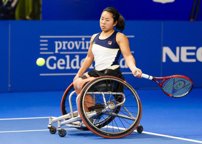 A female wheelchair tennis athlete in action at the Wheelchair Singles Masters