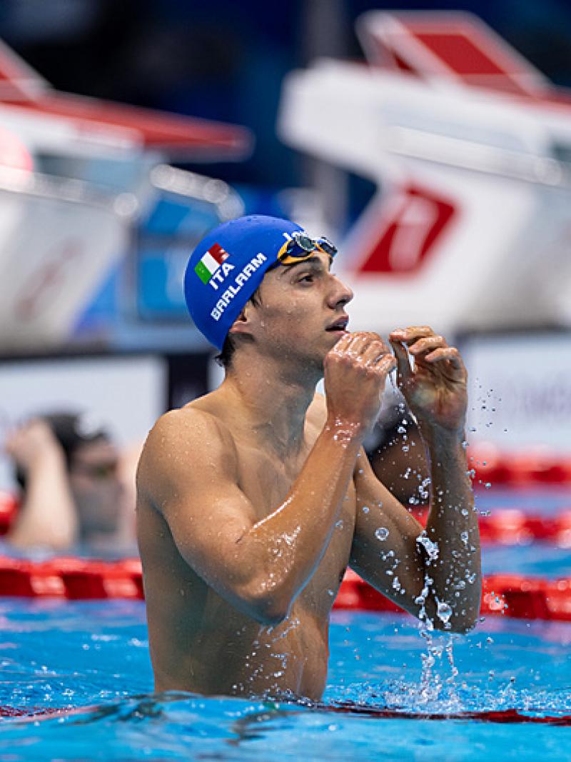 A male swimmer with a blue cap with the Italian flag in a swimming pool