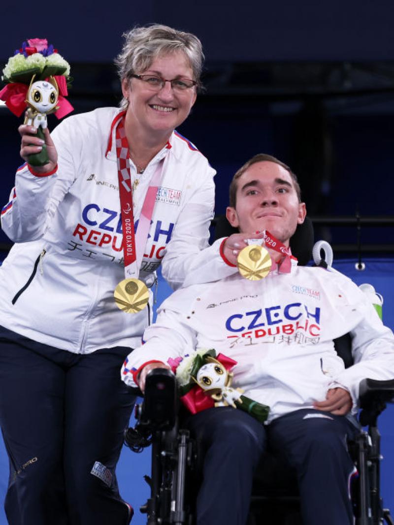 Adam Peska and Ivana Peskova smiling with their gold medals 