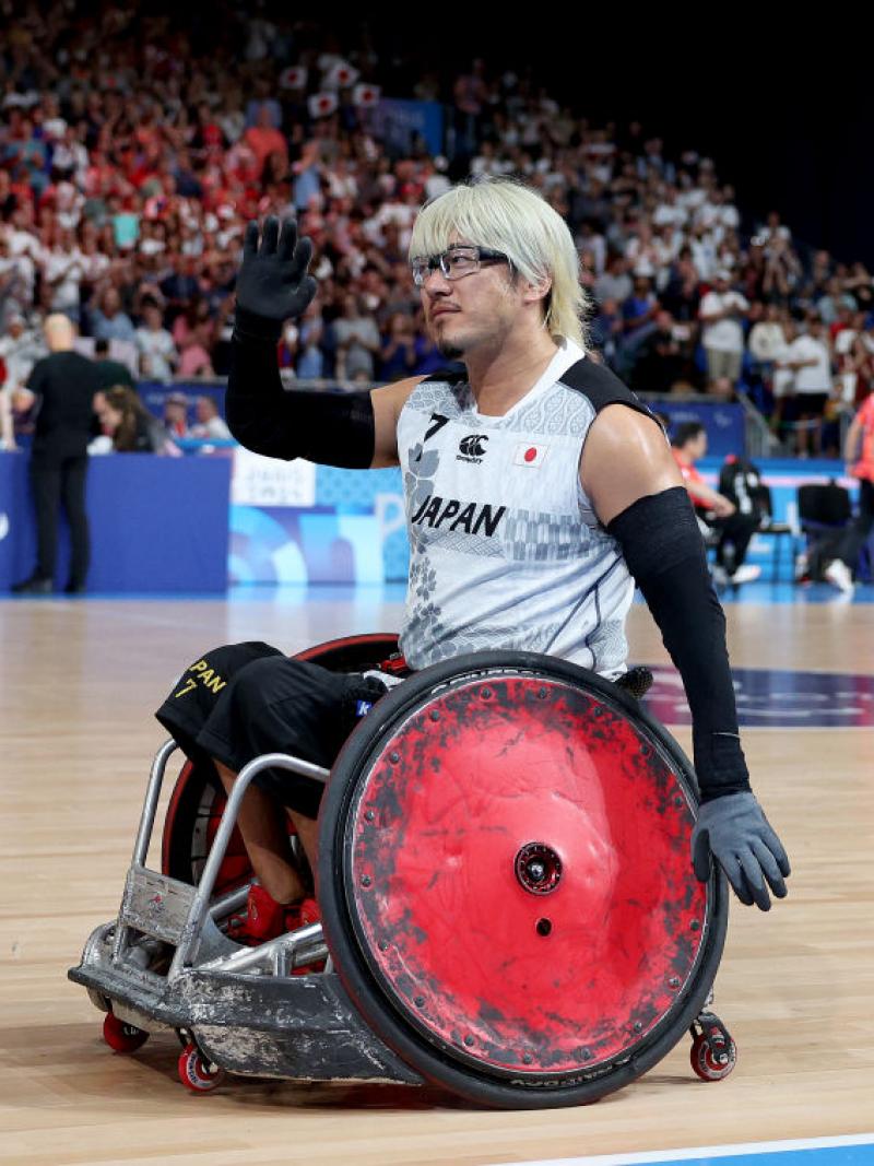 Wheelchair rugby player Daisuke Ikezaki waves to the crowd