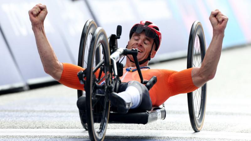 Para cyclist Jetze Plat celebrates crossing the finish line