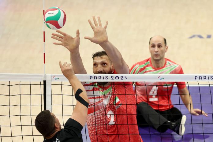 Sitting volleyball player Morteza Mehrzadselakjani of Team Islamic Republic of Iran plays the ball in front of the net