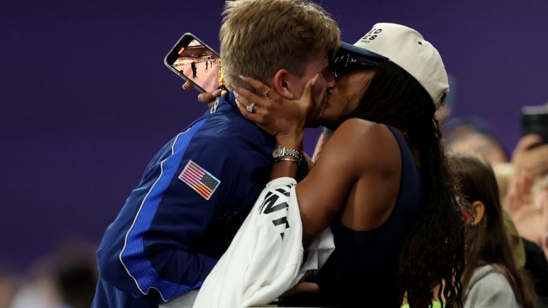 A man and a woman kissing in a stadium