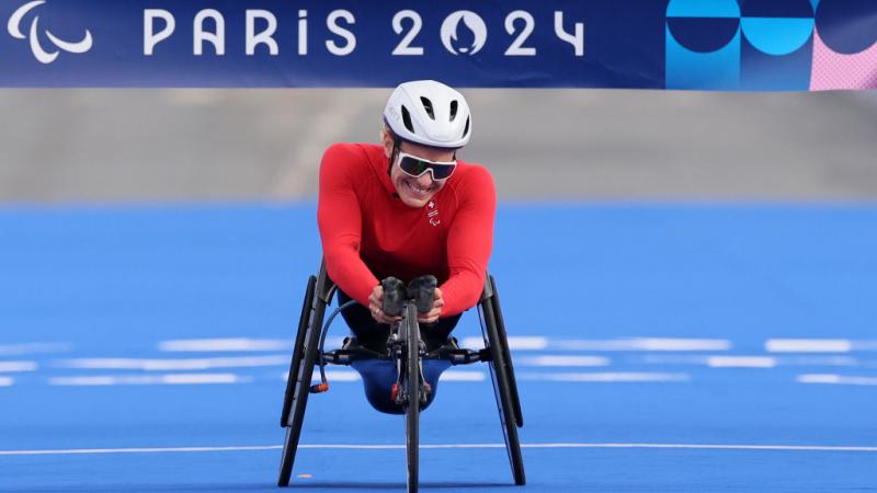 A female wheelchair racer crossing the finish line of the Paris 2024 marathon