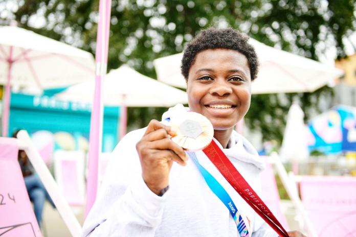 Mariam Eniola Bolaji holds her medal up and smiles