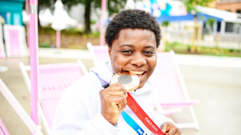 Mariam Eniola Bolaji bites her medal 