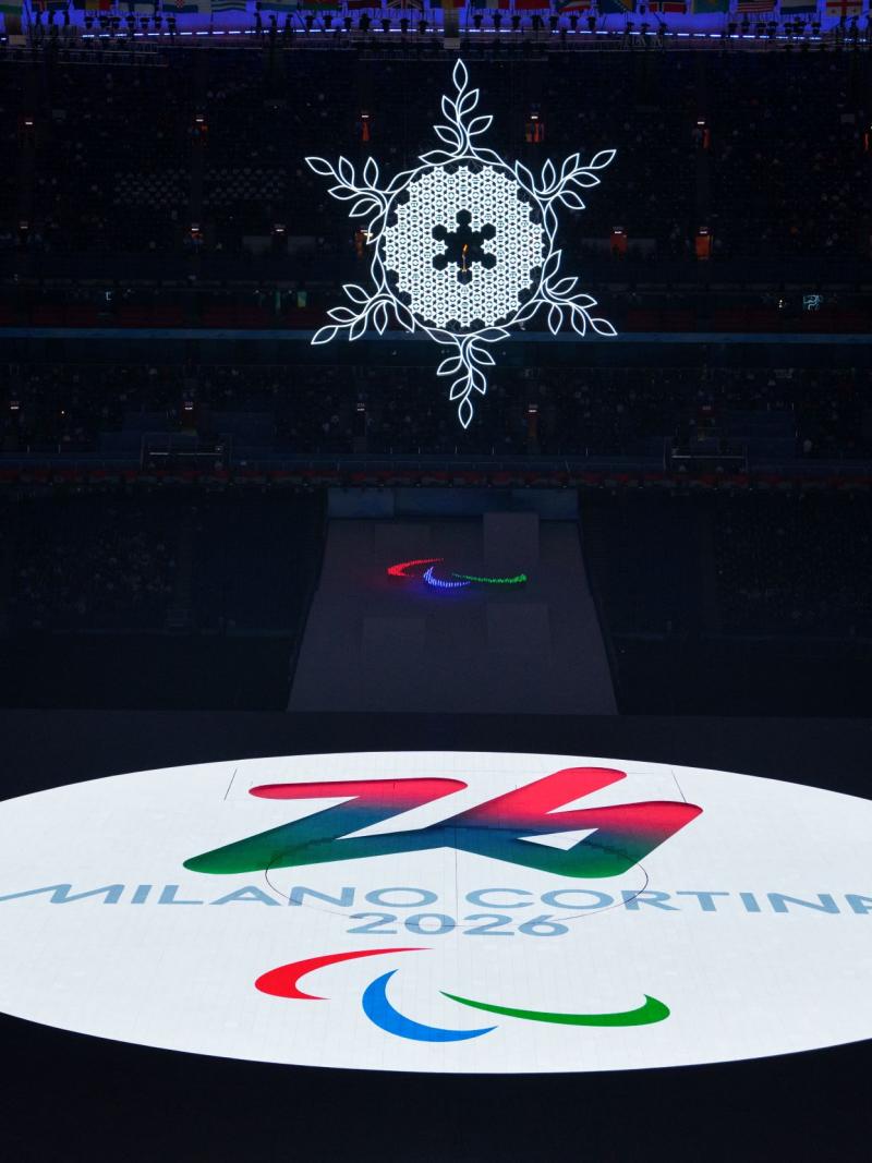 The logo of the Milano Cortina 2016 Paralympic Winter Games is projected as a bright white circle onto the stage during the handover at the Beijing 2022 Paralympic Winter Games Closing Ceremony.