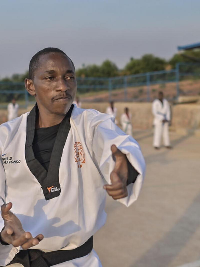 African male taekwondo athlete teaching other students