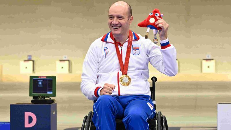 An athlete poses on podium